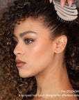 Model detangling curly hair with ZIGZAG Travel Hair Brush for gentle smoothing and scalp massage for healthy hair growth stimulation.